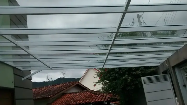 Cobertura de vidro temperado com estrutura de alumínio sobre quintal