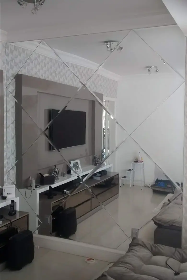 Painel de espelho bisotê decorativo na parede da sala de estar
