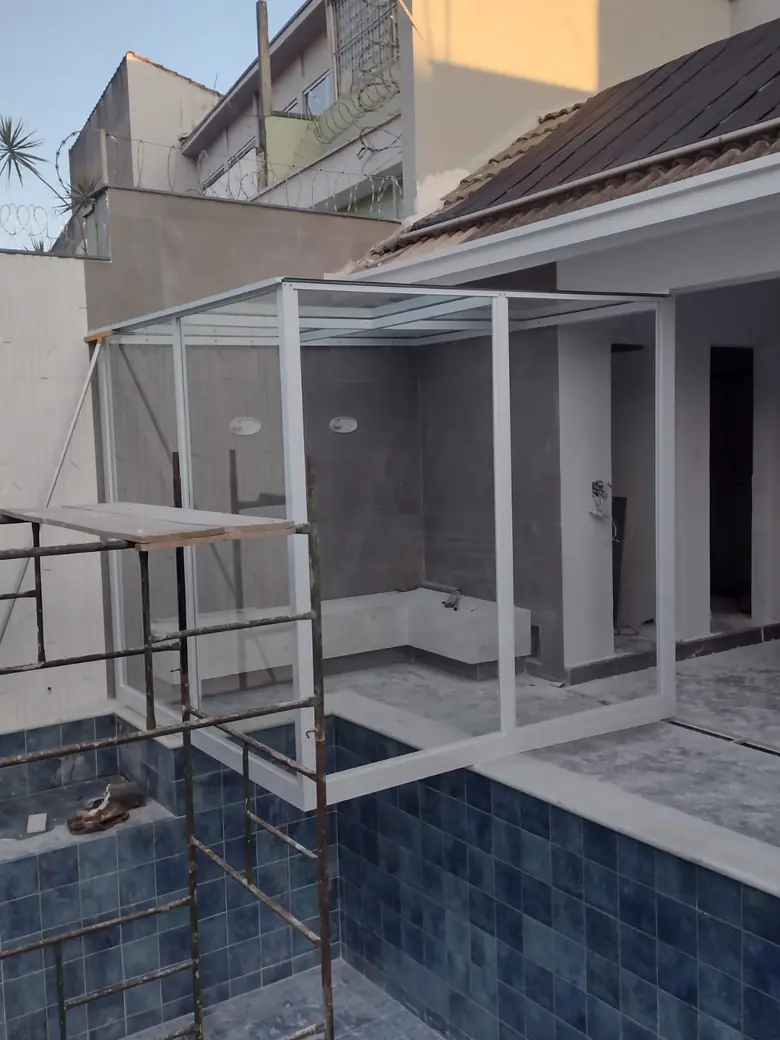 Fechamento em vidro temperado de sauna em frente a uma piscina