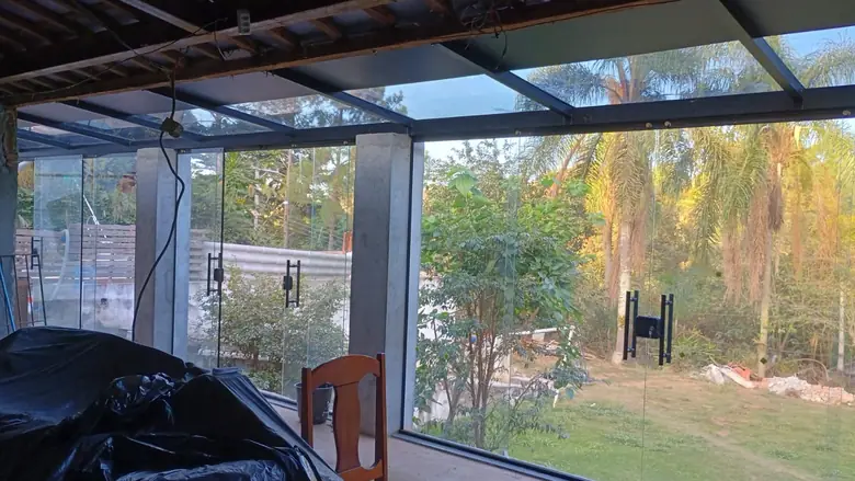 Fechamento de vidro temperado em garagem com vista para o jardim