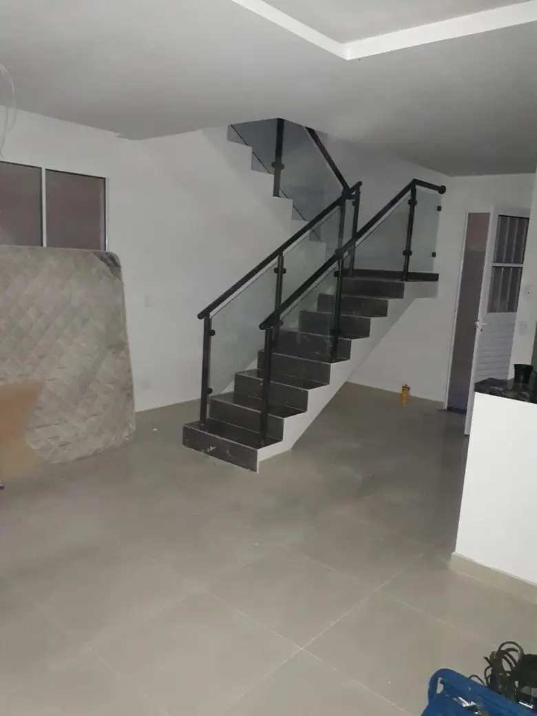 Guarda-corpo de vidro com corrimão de ferro pintado em escada de mármore