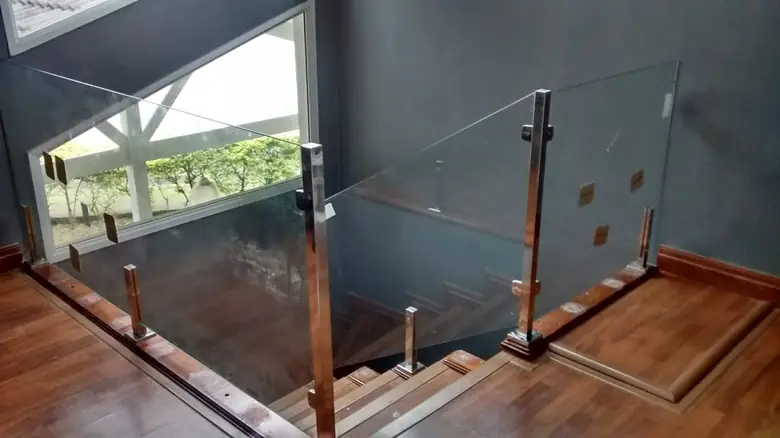 Guarda-corpo de vidro temperado com prumos de inox em escada interna