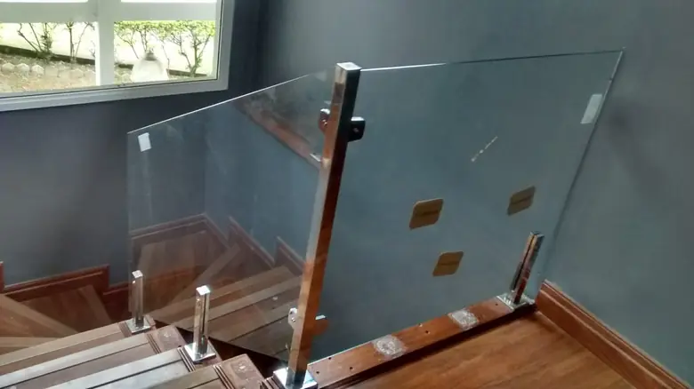 Guarda-corpo de vidro em escada com degraus de madeira e prumos de inox
