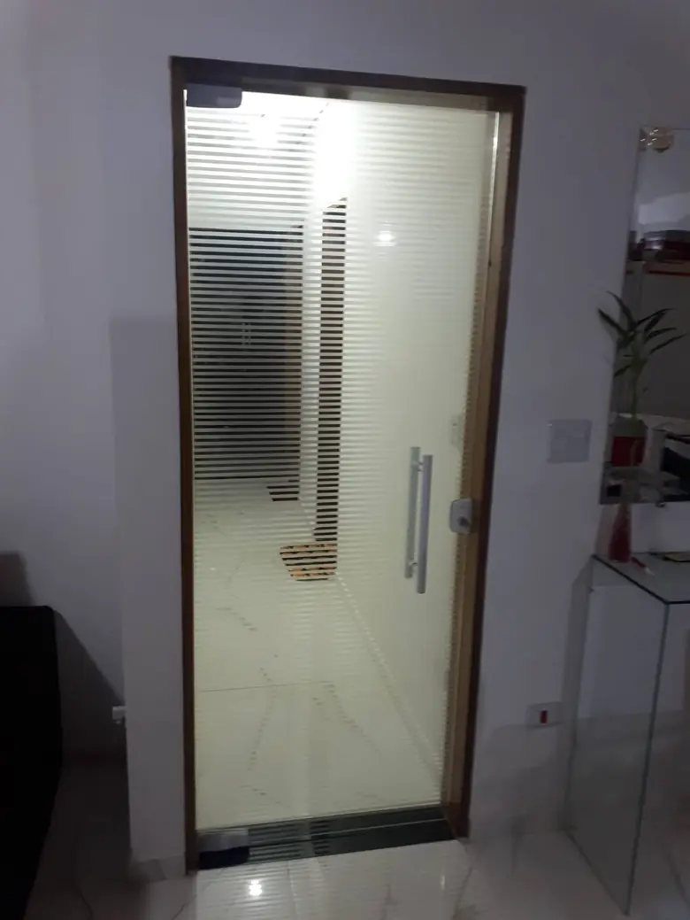 Porta de vidro temperado jateado com puxador tubular e esquadria de alumínio
